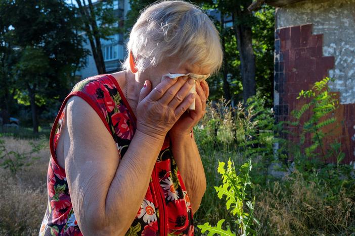 A woman reacts as rescuers evacuate the body of her husband, who was killed in a rocket attack on a residential area in Kharkiv on Monday. The head of Kharkiv's regional administration said a Russian strike on Ukraine's second-largest city killed at least four people and wounded 19 others, including four children.