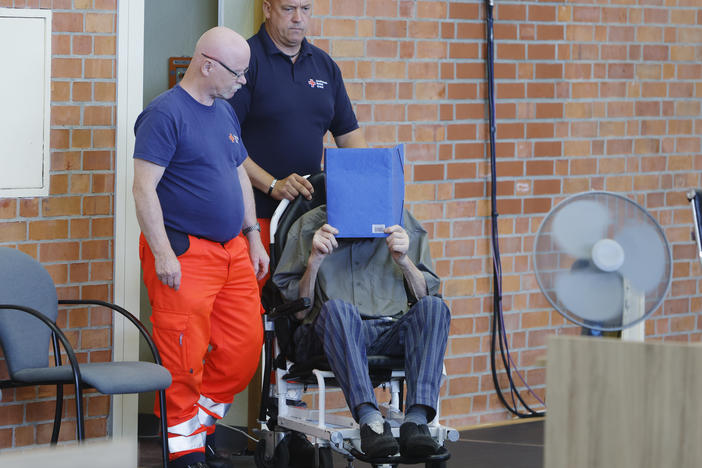 The accused Josef S. covers his face as he sits at the court room in Brandenburg, Germany, Tuesday, June 28, 2022.