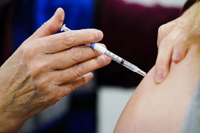 A health worker administers a dose of a COVID-19 vaccine during a vaccination clinic in Chester, Pa., on Dec. 15, 2021.
