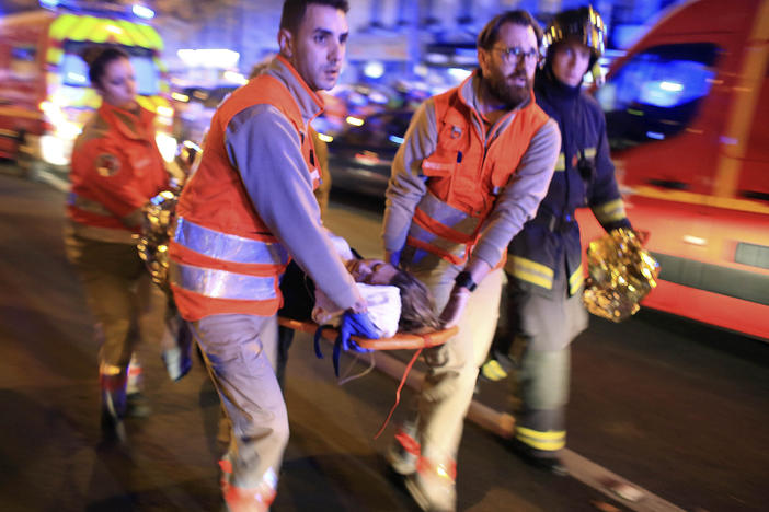 A woman is evacuated from the Bataclan concert hall in Paris after a shooting on Nov. 13, 2015.