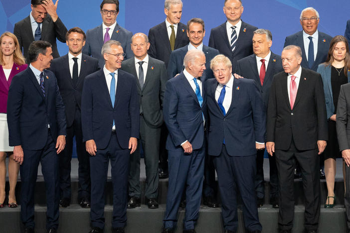 British Prime Minister Boris Johnson stands beside President Biden and other world leaders posing for a photo during the NATO summit on Wednesday in Madrid, Spain. The defense alliance declared Russia a direct threat and members are committing to boost troop levels and position heavy equipment along NATO's eastern flank.