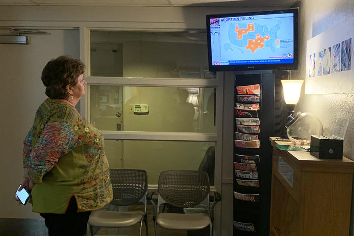 Kathaleen Pittman, administrator at Hope Medical Group in Shreveport, watches local TV news discussing a temporary restraining order the clinic won on Monday against Louisiana's abortion bans.