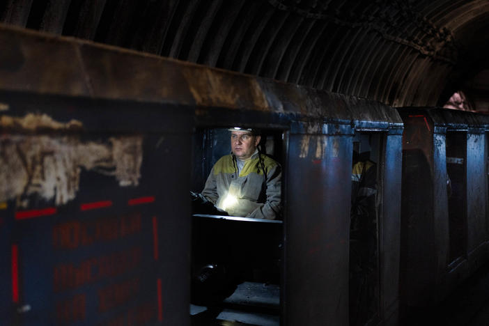 An employee at a coal mine in eastern Ukraine travels deep into the mine.