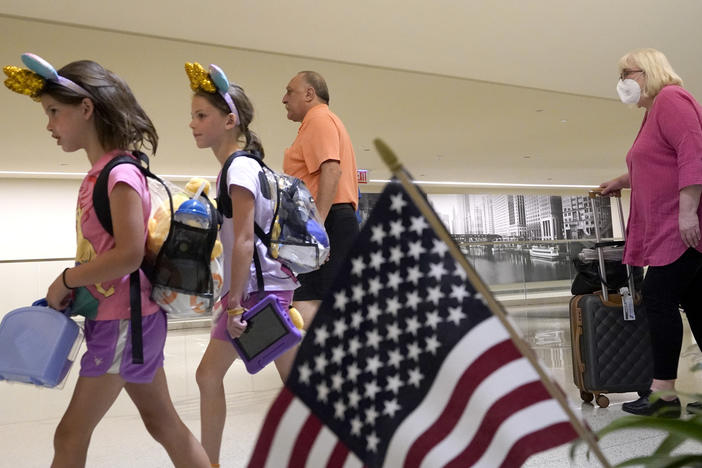 Airline passengers arrive at Chicago's Midway International Airport on the first day of the July Fourth holiday weekend on Friday.