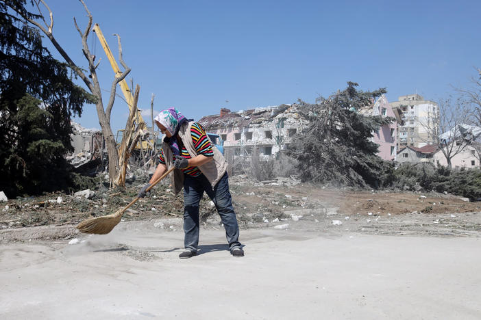 A woman cleans the area in front of a building hit by a missile strike in the Ukrainian town of Serhiivka, near Odesa, on Friday. The attack killed at least 18 people and injured 30.
