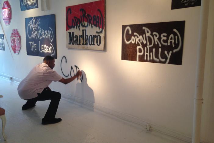Darryl "Cornbread" McCray tags the wall at Paradigm Gallery in Philadelphia.