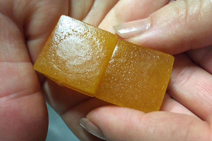 An employee displays a limeade-flavored cannabis-infused gummy candy at the Chalice Farms industrial kitchen in Portland, Ore., in June 2016.