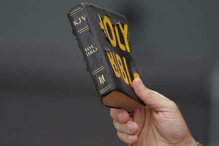 Bryan Peden, an anti-abortion supporter stands outside the Jackson Women's Health Organization clinic in Jackson, Miss., and waves his King James version of the Bible, as he cries out to women entering the medical facility to not have and abortion, Saturday, July 2, 2022.