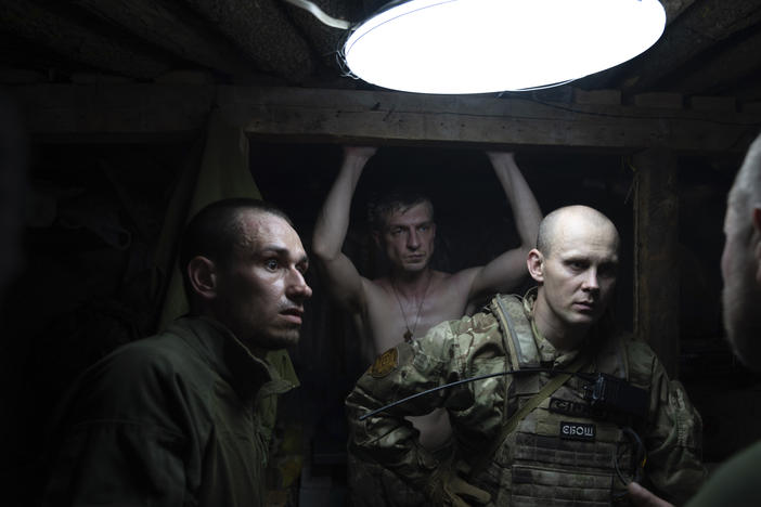 Ukrainian servicemen speak in the shelter at their position at the frontline near Kharkiv, Ukraine, on Saturday, July 2, 2022.