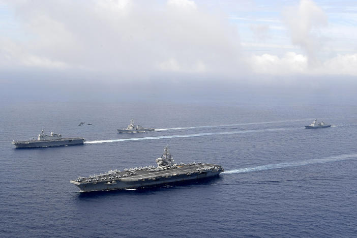 FILE - In this photo provided by South Korea's Defense Ministry, U.S. nuclear-powered aircraft carrier USS Ronald Reagan, second from left, and South Korea's landing platform helicopter (LPH) ship Marado, left, sail during a joint military exercise at an undisclosed location, June 4, 2022.