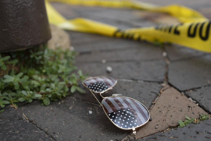 Police crime tape is seen near an American flag-themed sunglasses at the scene of the Fourth of July parade shooting in Highland Park, Ill.