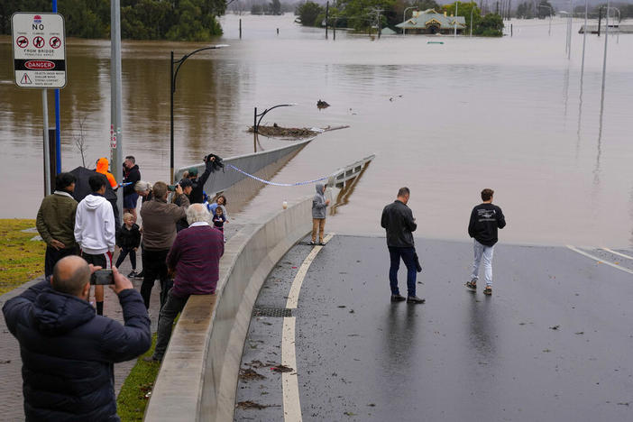 People look Tuesday at the flooded Windsor Bridge at Windsor on the outskirts of Sydney, Australia.