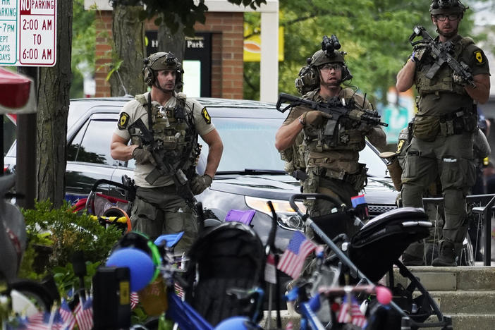 Law enforcement personnel secure the scene after a mass shooting Monday at a Fourth of July parade in downtown Highland Park, a Chicago suburb.