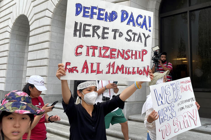 Demonstrators hold up signs outside the 5th U.S. Circuit Court of Appeals building in New Orleans on Wednesday as a panel of judges heard arguments on the Obama-era program that prevents the deportation of thousands of immigrants brought into the U.S. as children.