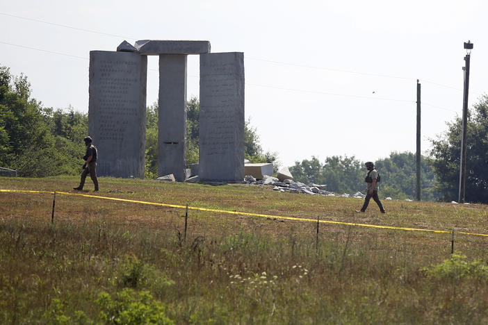 Law enforcement officials walk around the damaged Georgia Guidestones monument near Elberton, Ga., on Wednesday.
