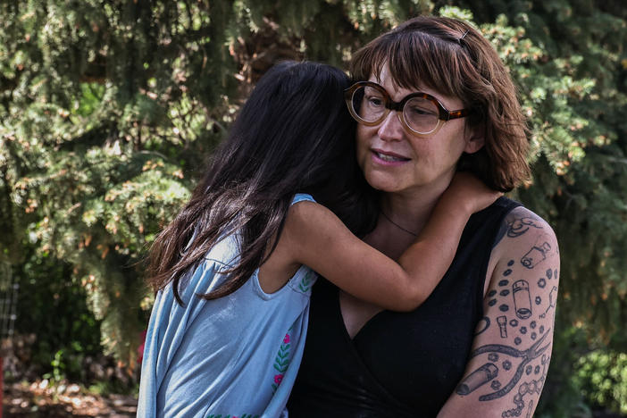 Jeni Rae Peters and daughter embrace at their home in Rapid City, S.D. In 2020, Peters was diagnosed with stage 2 breast cancer. After treatment, Peters estimates that her medical bills exceeded $30,000.