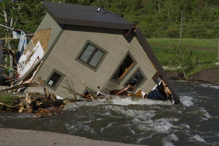 A house sits in Rock Creek after floodwaters washed away a road and a bridge in Red Lodge, Mont., on June 15, 2022.