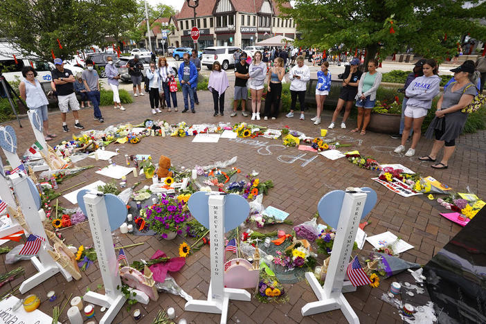 Area residents visit a memorial Wednesday to the seven people who lost their lives in the Highland Park, Ill., Fourth of July mass shooting.
