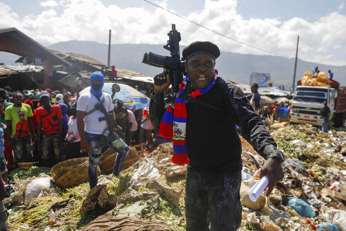 Barbecue, the leader of the "G9 and Family" gang, stands next to garbage Oct. 22 to call attention to the conditions people live in as he leads a march against kidnapping through La Saline neighborhood in Port-au-Prince, Haiti. The group said they were also protesting poverty and for justice in the slaying of President Jovenel Moise.