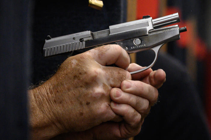 Shooting range owner John Deloca fires his pistol at his range in Queens, N.Y.
