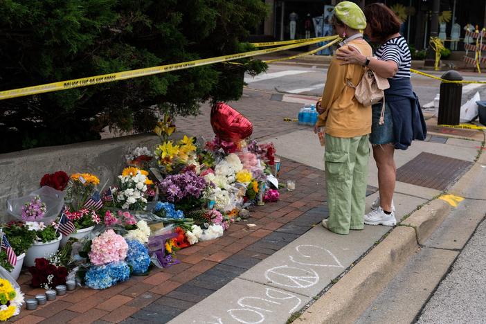 Residents visit a makeshift memorial for victims of the 4th of July mass shooting in downtown Highland Park, Illinois on Wednesday.
