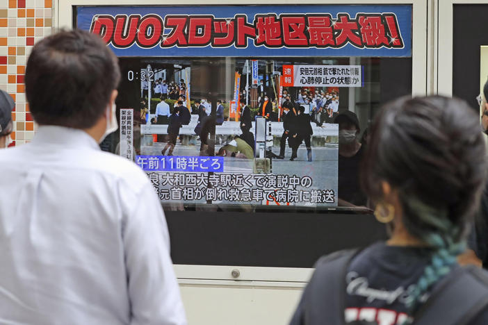 People in Tokyo watch TV news reporting Japan's former Prime Minister Shinzo Abe was shot on Friday.