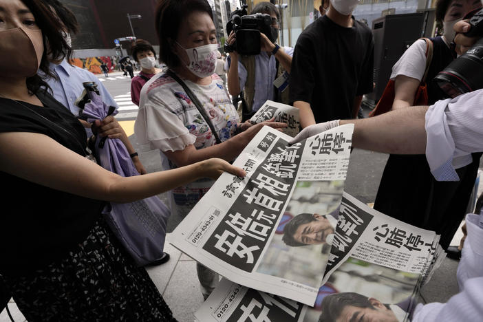 An employee of the Yomiuri Shimbun distributes extra editions of the newspaper in Tokyo with reporting on the shooting of Japan's former Prime Minister Shinzo Abe on Friday.