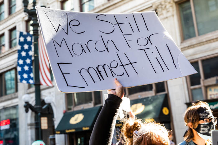 A woman holds a sign in honor of Emmett Till during a protest on June 13, 2020 in Chicago, Ill. Till's family urged authorities to move on a recently discovered unserved warrant from 1955 that charges a white woman for the murder and kidnapping of the teenager.