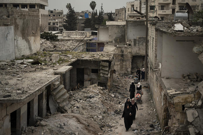 Women walk in a neighborhood heavily damaged by airstrikes in Idlib, Syria, on March 12, 2020.