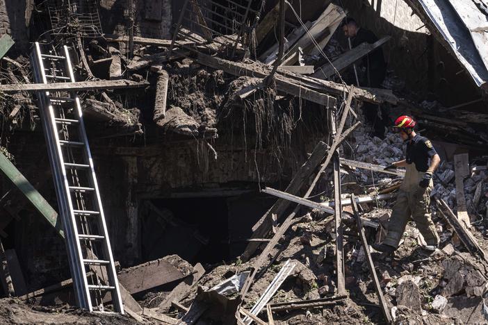 Rescue worker and police officer inspect a site of destroyed house after a Russian attack in a residential neighbourhood in downtown Kharkiv, Ukraine, on Saturday, July 9, 2022. (AP Photo/Evgeniy Maloletka)