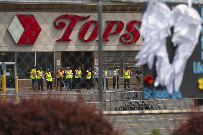 Tops Markets announced Monday that its Buffalo, N.Y. location will reopen on July 15 following the deadly mass shooting in May. Here, investigators stand outside during a moment of silence for the victims of the Buffalo supermarket shooting outside the Tops Friendly Market on Saturday, May 21, 2022.