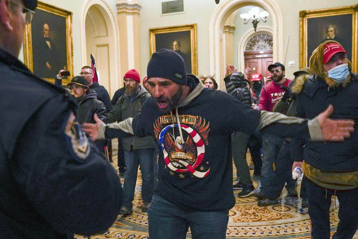 The congressional committee investigating the Jan. 6, 2021 attack on the Capitol will focus on the role of QAnon and extremist groups like the Oath Keepers and Proud Boys in its upcoming hearing. Prosecutors have identified the man at the center of this photograph as a QAnon-supporter named Douglas Jensen. Jensen has pleaded not guilty to all charges.