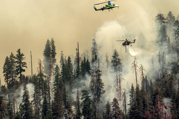 A helicopter drops water on the Washburn Fire burning in Yosemite National Park on Saturday.
