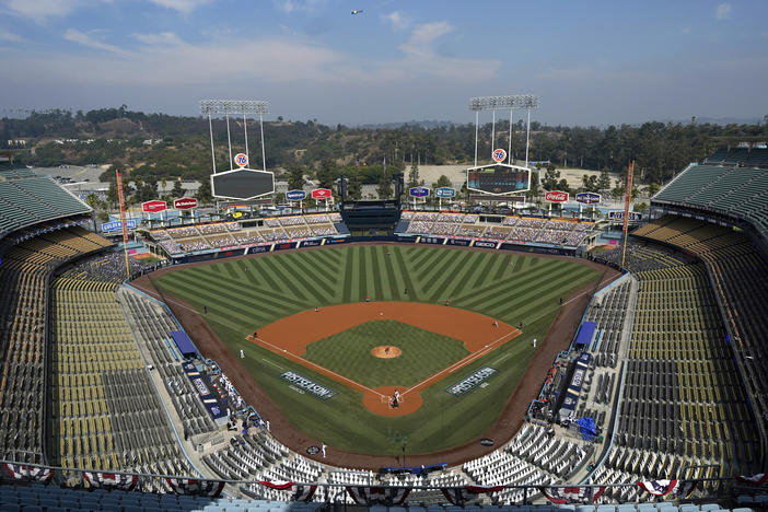 Empty seats and cutouts are viewed in Dodger Stadium as Houston Astros' Lance McCullers Jr. pitches against the Oakland Athletics during the first inning of Game 1 of a baseball American League Division Series in Los Angeles, Oct. 5, 2020. Concession workers at the stadium have voted to authorize a strike days ahead of MLB's All-Star Game festivities in Los Angeles.