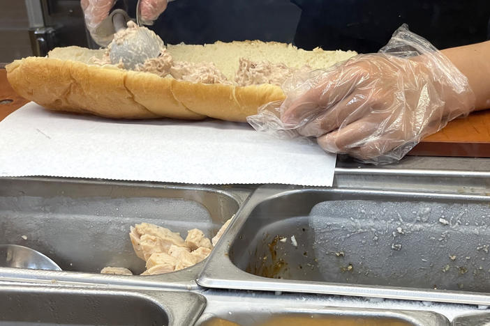 A worker at a Subway sandwich shop makes a tuna sandwich last year in San Anselmo, California. A lawsuit in federal court accuses the restaurant giant of not using 100% tuna in its offerings — and a judge has denied Subway's request to dismiss the suit.
