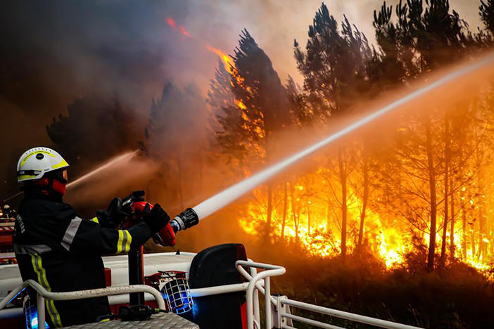 This photo provided by the fire brigade of the Gironde region shows firefighters battling a wildfire on Thursday near Landiras, in southwestern France.