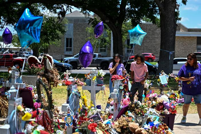 People visit a makeshift memorial to the victims of a shooting at Robb Elementary School outside the Uvalde County Courthouse on June 30.