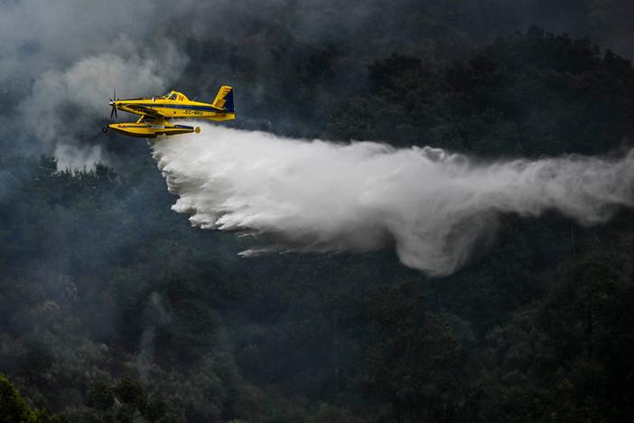 A firefighter aircraft drops water in a wildfire in Portugal on Saturday.