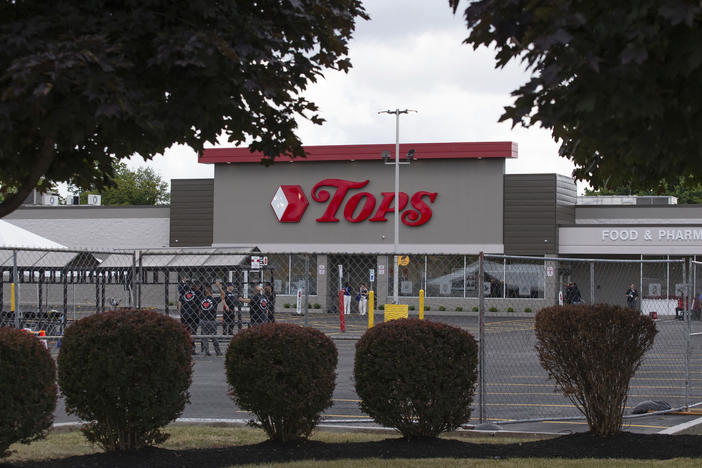 People stand in the parking lot of the Tops Friendly Market last week in Buffalo, N.Y., last week.