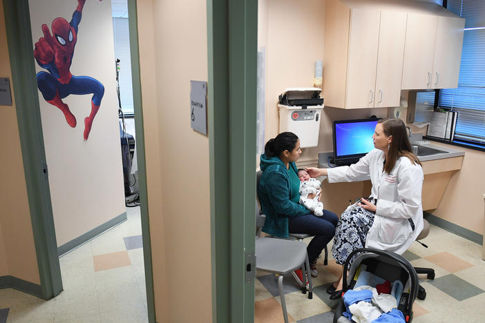 Ana Elsy Ramirez Diaz holds her baby as he is seen by Dr. Margaret-Anne Fernandez during a checkup visit at INOVA Cares Clinic for Children in Falls Church, Va. A portion of the clinic's patients are insured through the Children's Health Insurance Program.