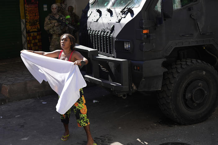 A resident waves a white sheet in protest and to ask for peace after a police operation that resulted in multiple deaths, in the Complexo do Alemao favela in Rio de Janeiro on Thursday.