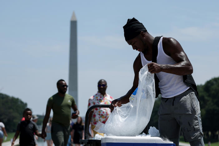 A vendor fills a cooler with ice during a heat wave in front of the Lincoln Memorial on Friday in Washington, D.C.