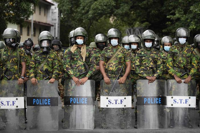 Police commandos stand guard at a barricade outside president's office in Colombo, Sri Lanka, on Friday.