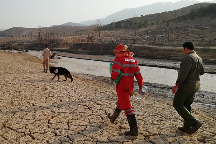 Members of a rescue team on Saturday search for missing people from flash floods in Iran's drought-stricken southern Fars province.