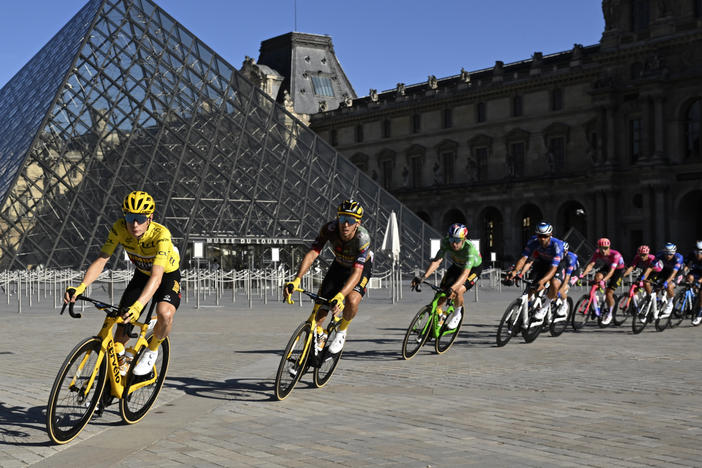 The pack with Denmark's Jonas Vingegaard, wearing the overall leader's yellow jersey, passes the Louvre Museum during the 21st stage of the men's Tour de France cycling race.
