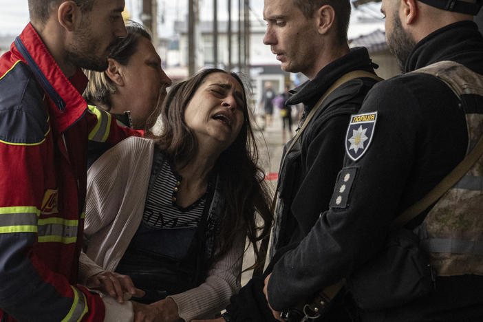 People try to console a woman named Sabina after her husband Artem Pogorelets was killed by Russian shelling in a market in Kharkiv, Ukraine, on Thursday.