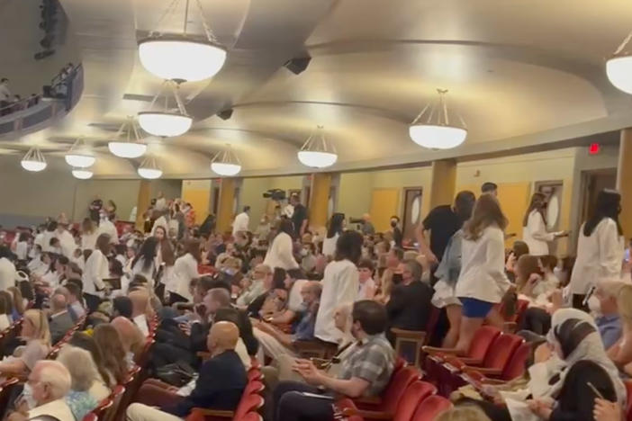 After receiving their white doctor's coats, dozens of incoming medical students at the University of Michigan walked out in protest of a keynote speaker with anti-abortion beliefs.