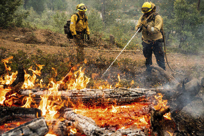 Firefighters mop up hot spots while battling the Oak Fire in the Jerseydale community of Mariposa County, Calif., on Monday.