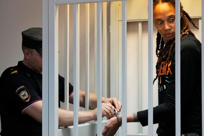 A guard removes Brittney Griner's handcuffs ahead of a hearing at the Khimki Court outside Moscow on Wednesday.