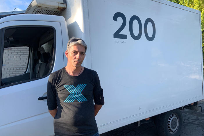 Oleg Repnoy stands in front of his Evacuation 200 vehicle. "My job is to accompany these heroes on their last trip home," he says.